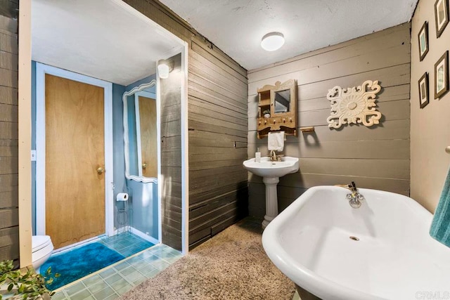 bathroom with a bathing tub and wooden walls