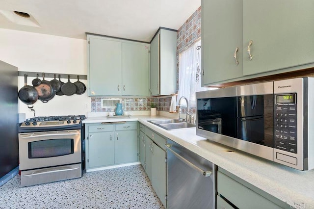 kitchen featuring appliances with stainless steel finishes, backsplash, and sink