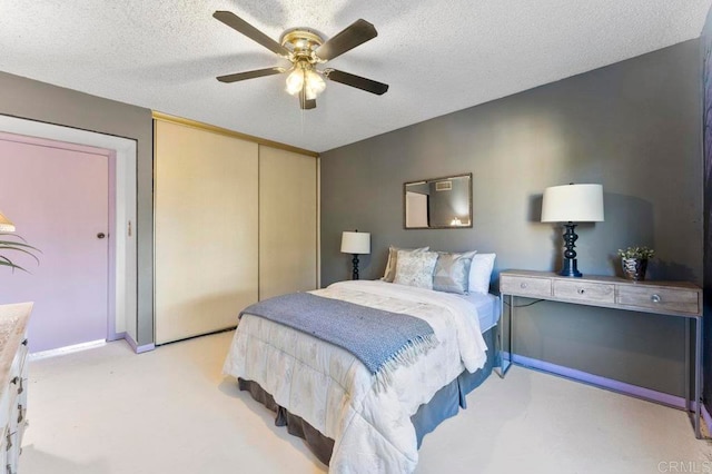 bedroom with ceiling fan, a textured ceiling, and a closet