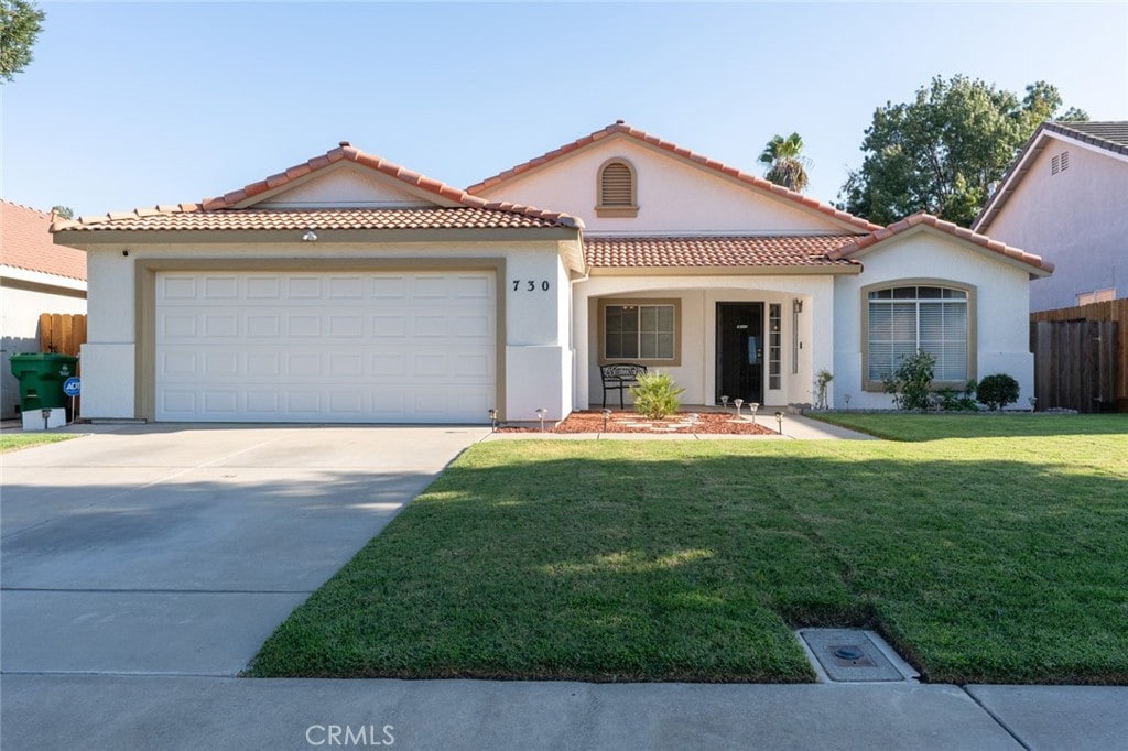 mediterranean / spanish home with a front yard and a garage