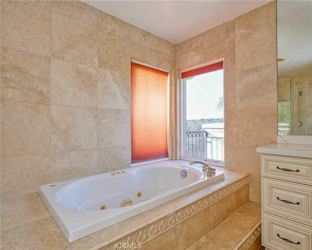 bathroom featuring vanity, tiled bath, and tile walls