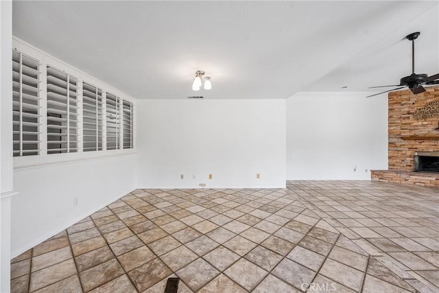 unfurnished living room featuring ceiling fan and a fireplace