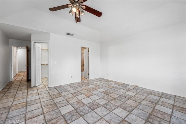 unfurnished bedroom with ceiling fan, a closet, a spacious closet, and ensuite bath