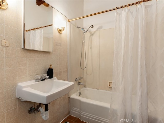 bathroom with shower / bath combination with curtain, tile walls, and sink