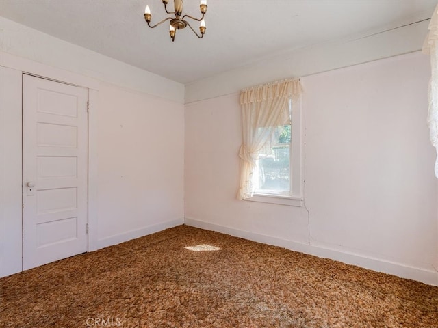 carpeted empty room with a chandelier