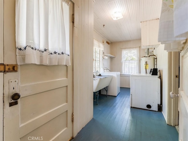 clothes washing area featuring separate washer and dryer, gas water heater, and dark hardwood / wood-style flooring