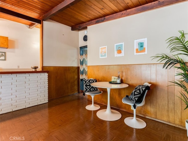 interior space featuring wooden ceiling, wood walls, and beamed ceiling