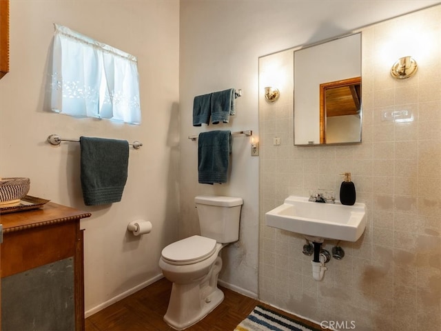 bathroom with tile walls, toilet, and sink