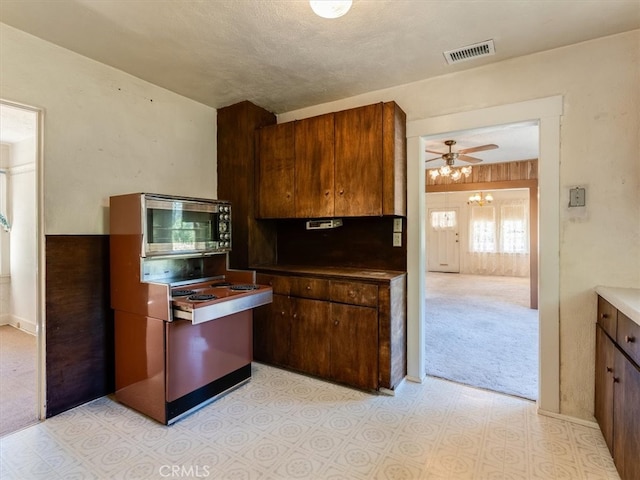 kitchen featuring ceiling fan, a textured ceiling, and light carpet