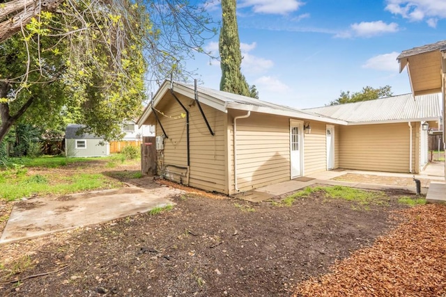 rear view of house featuring a storage shed