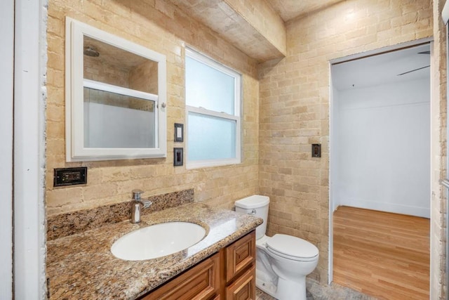 bathroom with hardwood / wood-style flooring, toilet, and vanity