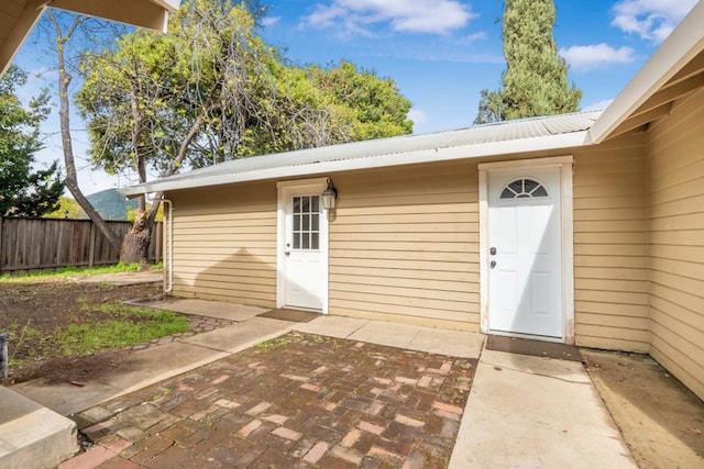 view of exterior entry with a patio