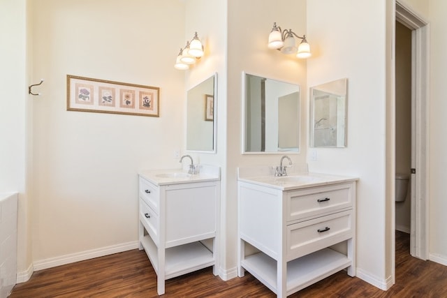 bathroom featuring toilet, vanity, and hardwood / wood-style floors