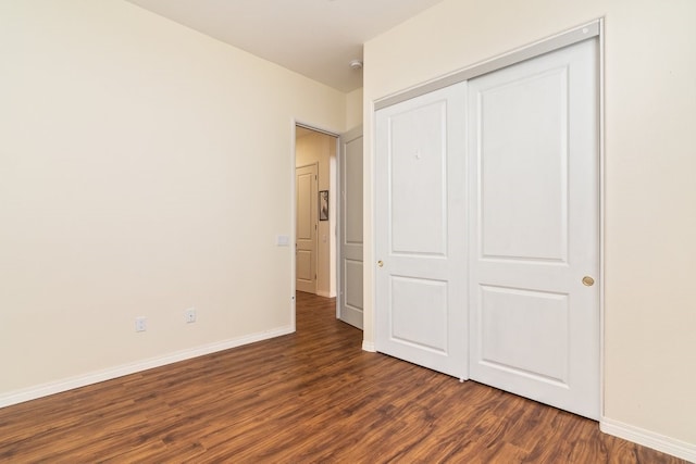 unfurnished bedroom with a closet and dark hardwood / wood-style floors