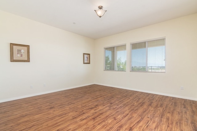 empty room featuring baseboards and wood finished floors