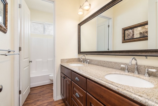 full bathroom with vanity, hardwood / wood-style flooring, toilet, and shower / bathtub combination