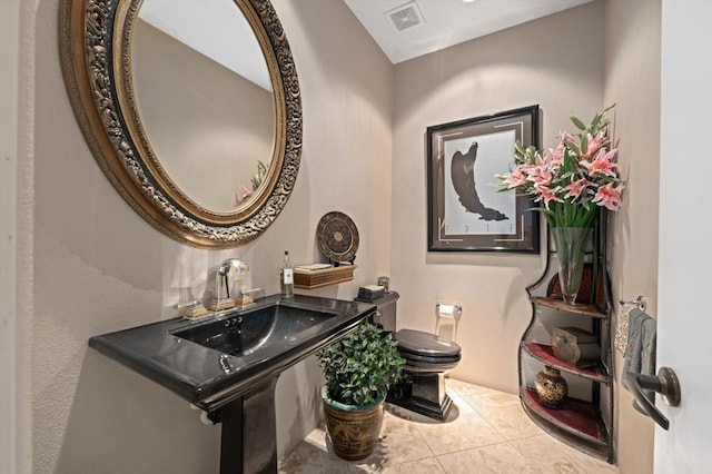 bathroom with tile patterned flooring, toilet, and sink