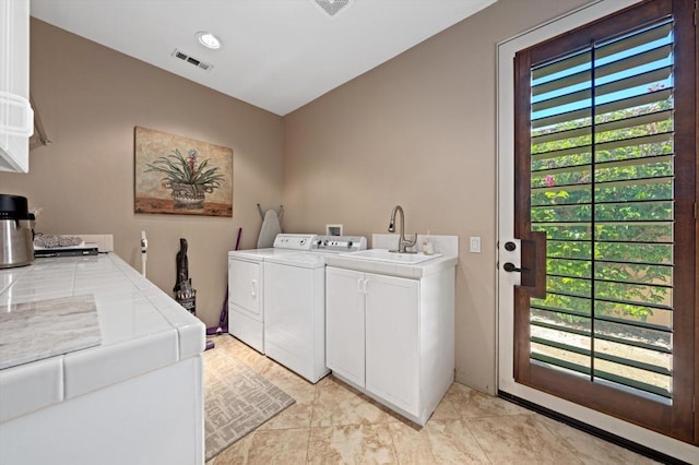 laundry area featuring light tile patterned flooring, sink, a wealth of natural light, and washing machine and clothes dryer