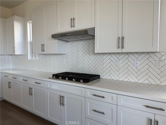 15949 Conservatory Dr, Fontana, CA 92336 - kitchen featuring under cabinet range hood, stainless steel gas cooktop, light countertops, white cabinetry, and tasteful backsplash