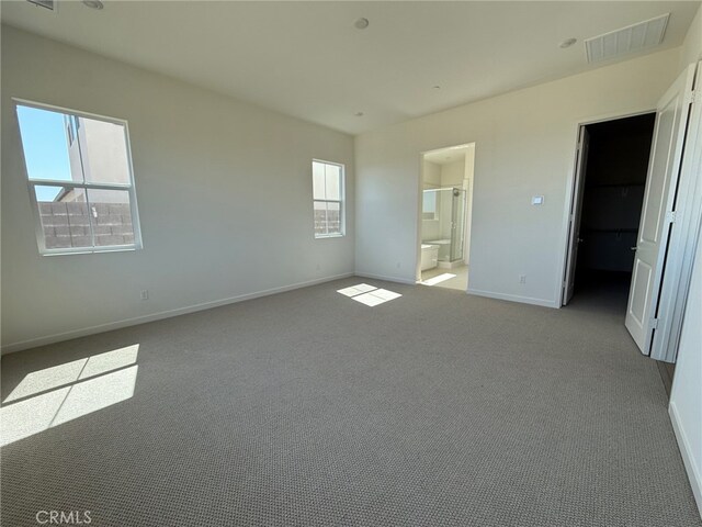 15949 Conservatory Dr, Fontana, CA 92336 - unfurnished bedroom with baseboards, carpet floors, a walk in closet, and ensuite bath