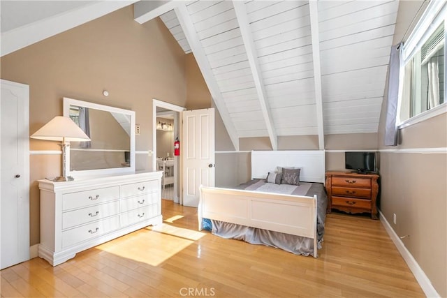 bedroom featuring beam ceiling, high vaulted ceiling, and light hardwood / wood-style flooring