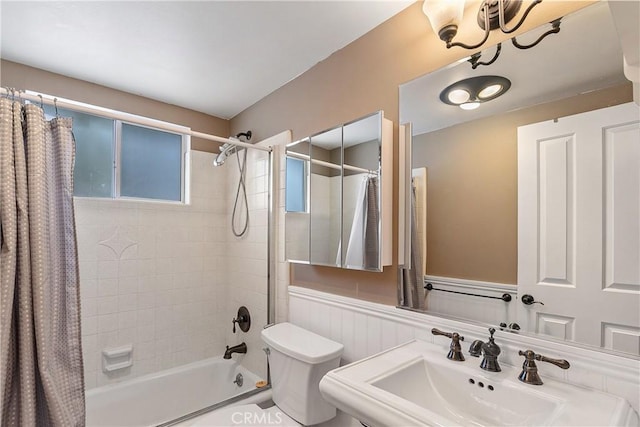 full bathroom featuring toilet, shower / bath combo with shower curtain, and sink