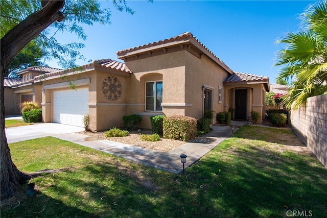 mediterranean / spanish home featuring a front yard and a garage