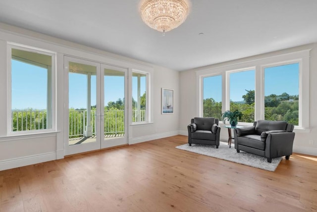 living area with plenty of natural light, a chandelier, and light hardwood / wood-style flooring