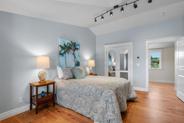 bedroom with hardwood / wood-style flooring and lofted ceiling