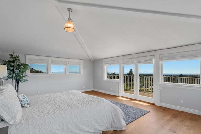 bedroom featuring access to exterior, lofted ceiling with beams, and light wood-type flooring