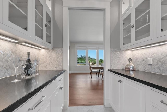 kitchen featuring white cabinets, light hardwood / wood-style flooring, and tasteful backsplash