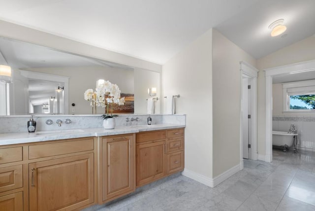 bathroom featuring vanity, a washtub, and vaulted ceiling