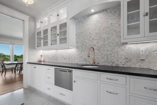 kitchen with backsplash, sink, white cabinets, and stainless steel dishwasher