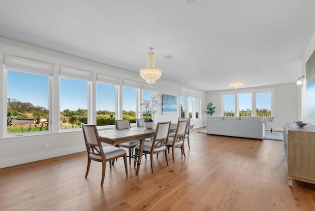 sunroom featuring a chandelier and plenty of natural light