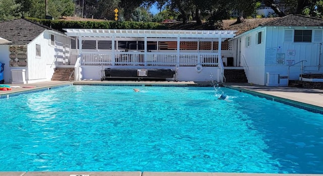 view of pool with a pergola, pool water feature, and a deck