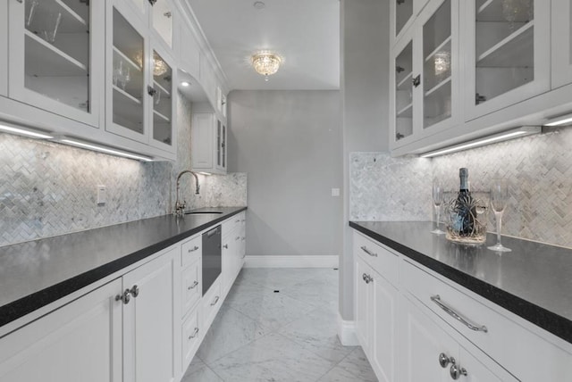 kitchen with white cabinetry, sink, and tasteful backsplash