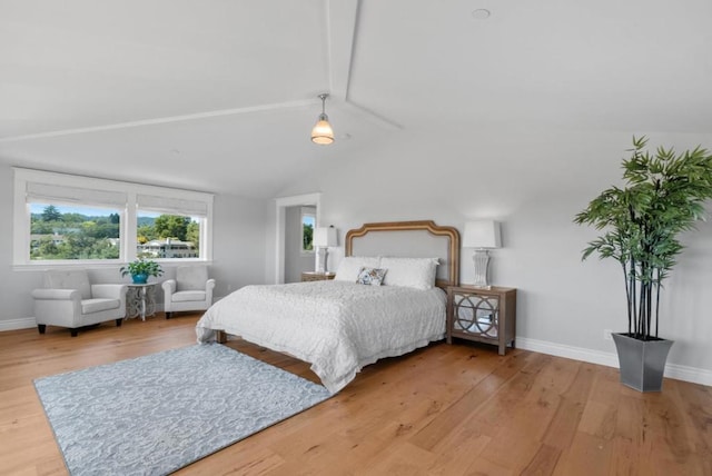 bedroom featuring vaulted ceiling with beams and wood-type flooring