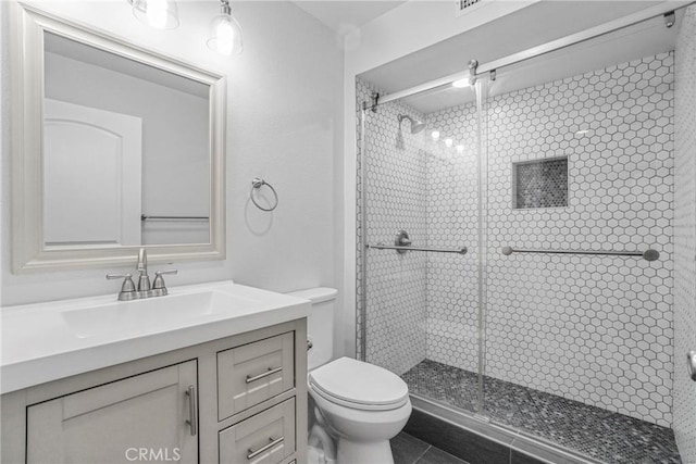 bathroom with toilet, vanity, and an enclosed shower