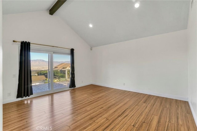 empty room featuring light hardwood / wood-style floors, beam ceiling, and high vaulted ceiling