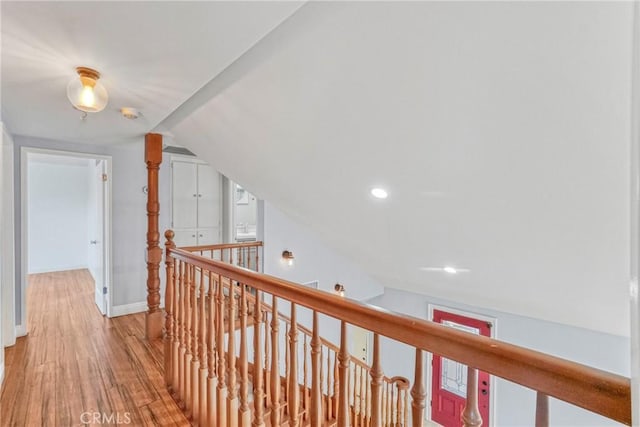 hall featuring lofted ceiling and light wood-type flooring