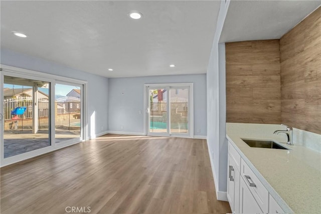 interior space featuring a wealth of natural light, sink, and light hardwood / wood-style flooring