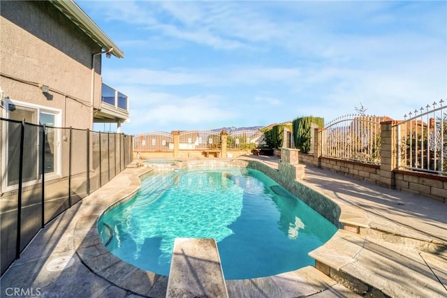 view of pool featuring a diving board and an in ground hot tub