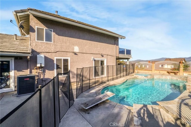 view of swimming pool with a diving board, a patio area, cooling unit, and an in ground hot tub