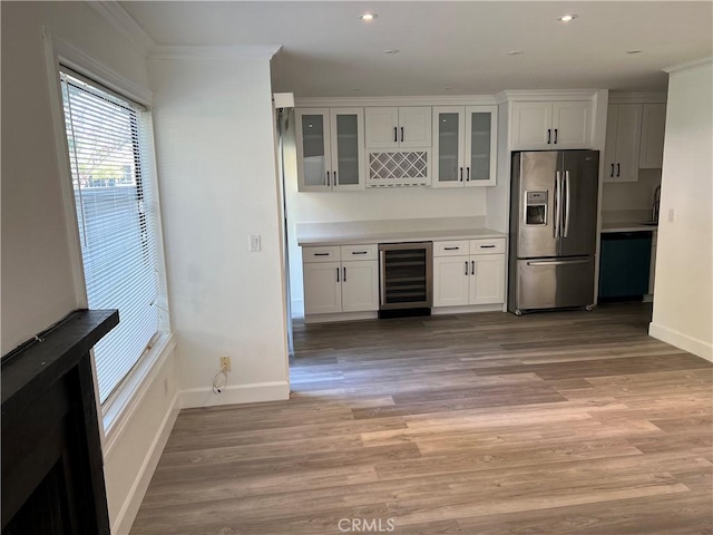 kitchen with wine cooler, stainless steel fridge with ice dispenser, light hardwood / wood-style flooring, white cabinets, and ornamental molding