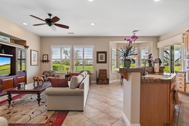 living room with ceiling fan, light tile patterned floors, and sink