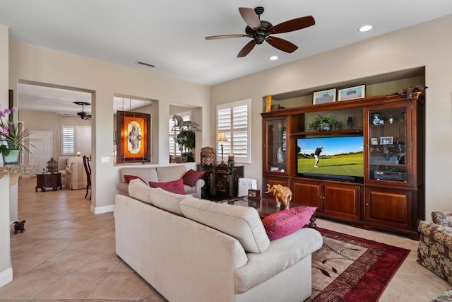 tiled living room featuring ceiling fan and plenty of natural light