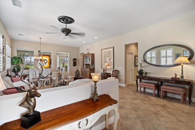 living room with a healthy amount of sunlight and ceiling fan with notable chandelier