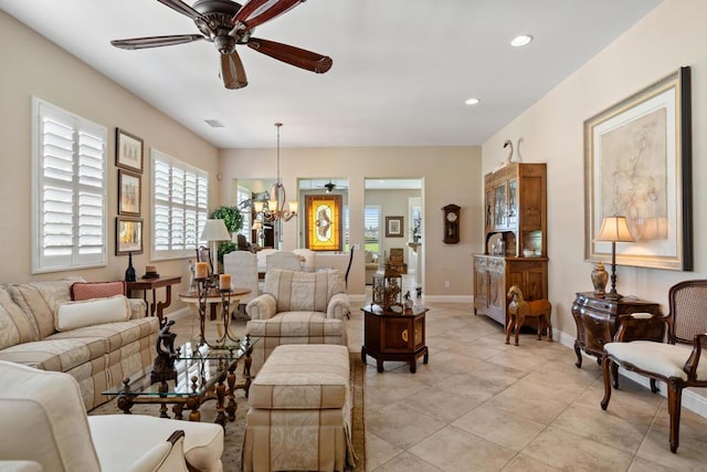 living room featuring light tile patterned floors and ceiling fan with notable chandelier