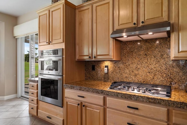 kitchen with light tile patterned floors, tasteful backsplash, stainless steel appliances, and light brown cabinetry