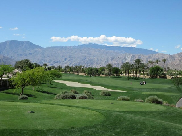 surrounding community with a mountain view and a yard